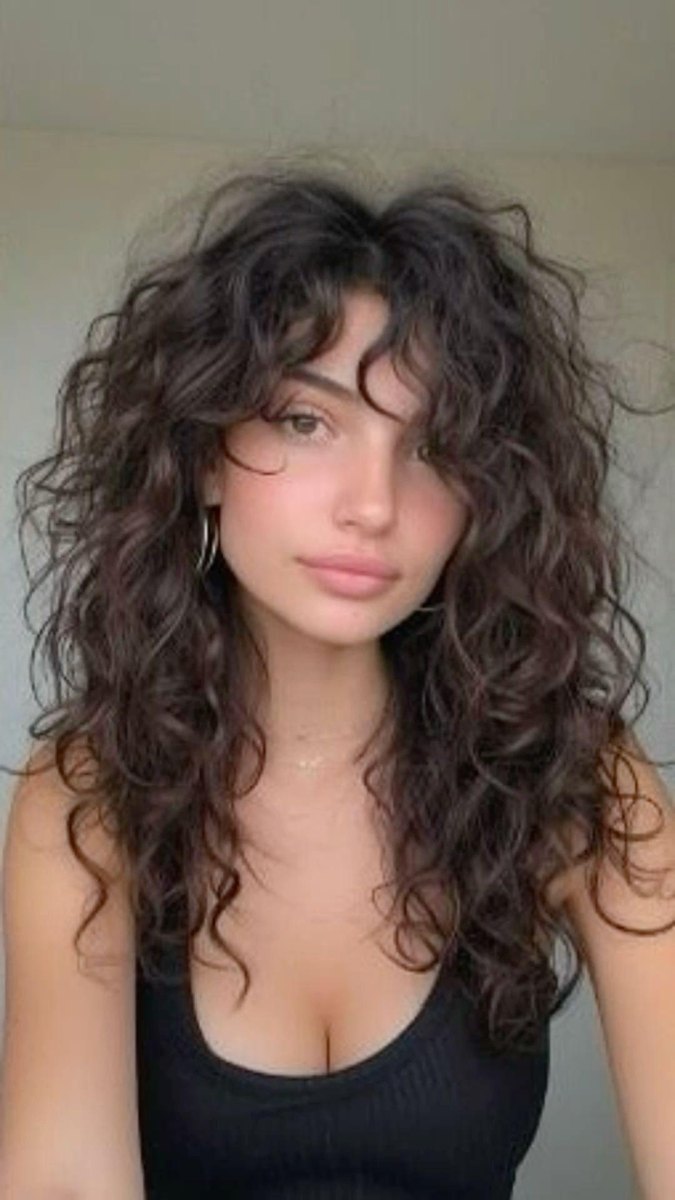 Krullend lang haar met curtain bangs